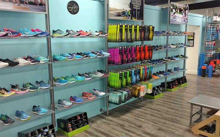 running shoes and socks along wall inside store at fleet feet delray beach