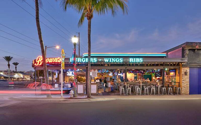 side view at night of neon lighted restaurant with outdoor seating at johnnie browns delray beach