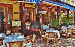 sidewalk dining area with shady awnings and trees at tramonti delray beach