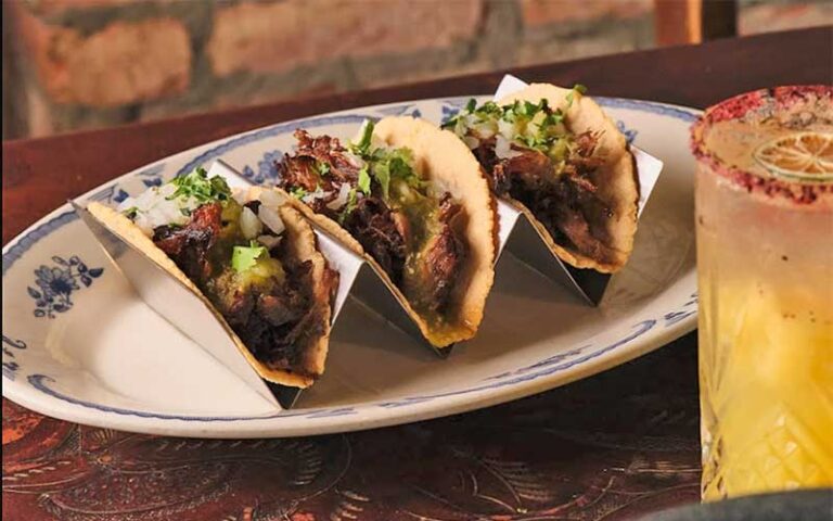 specialty tacos in tray with cocktail at roccos tacos tequila bar delray beach