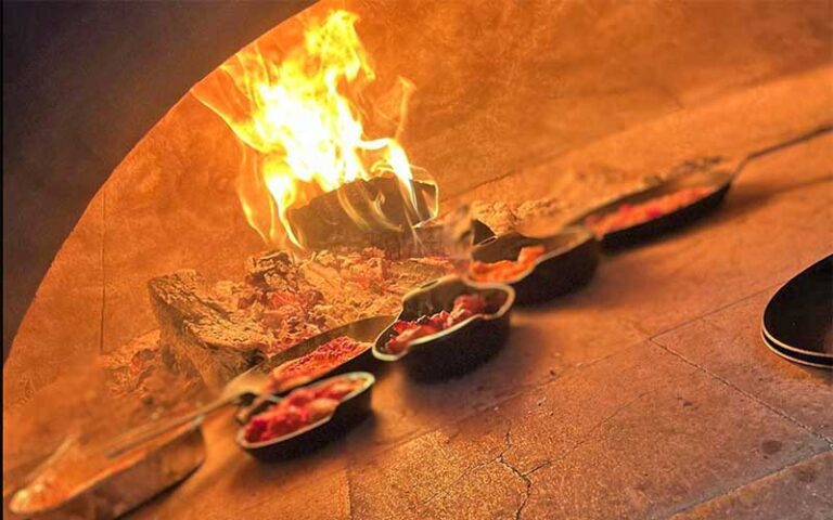 stone oven with fire and entrees at wood fire delray beach