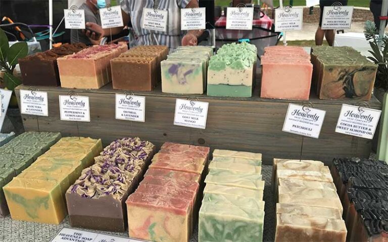 table with rows of handmade soaps at delray beach greenmarket