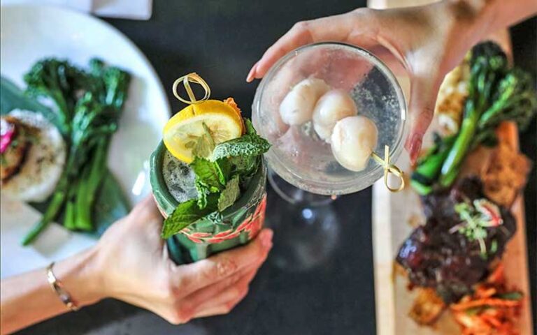 toasting cocktails over table of entrees at lemongrass asian bistro delray beach