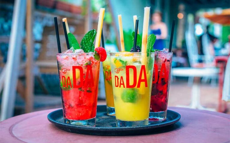 tray of colorful cocktails in branded glasses at dada delray beach