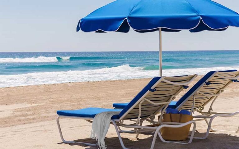 two lounger chairs and umbrella on beach at the seagate beach club delray beach