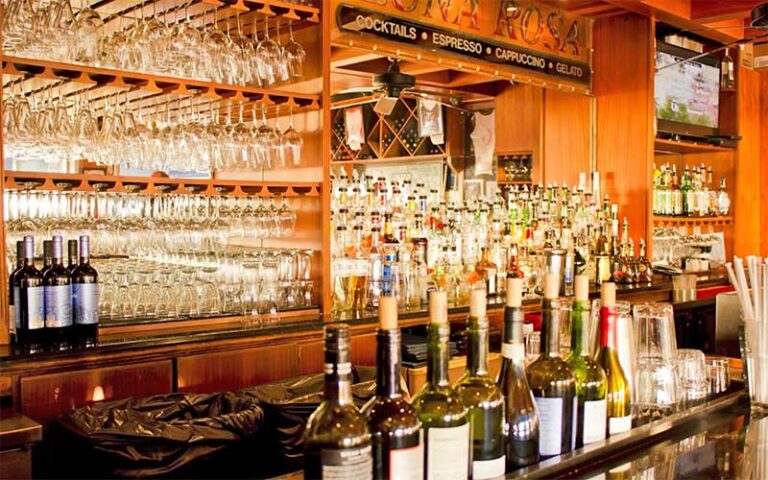 wood panel bar with bottles and glasses at caffe luna rosa delray beach