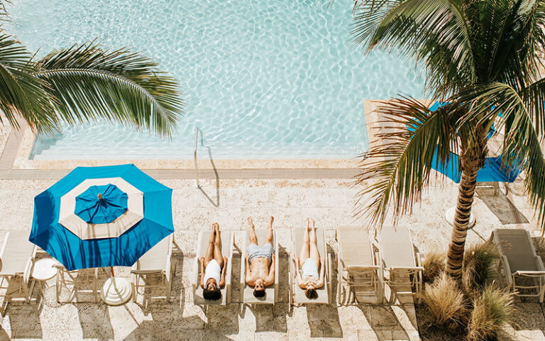 aerial view above pool with sunbathers on loungers at opal grand resort spa delray beach