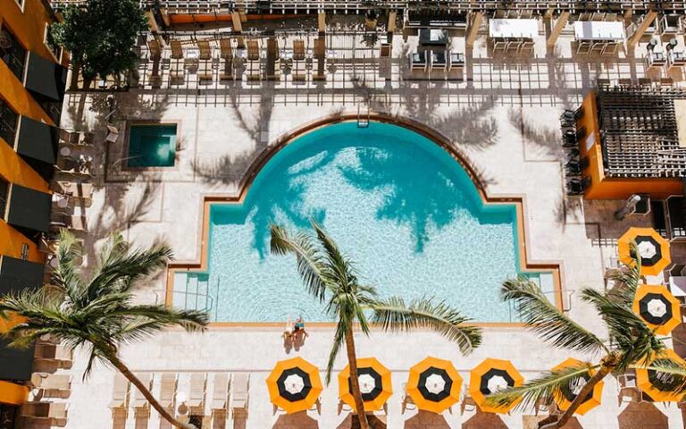 aerial view of courtyard pool with umbrellas and seating at the atlantic suites on the ave delray beach