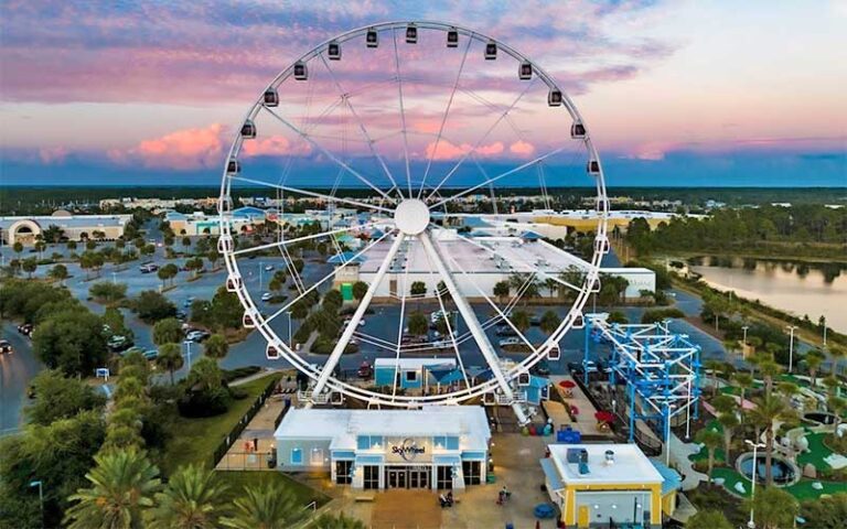 aerial view of ferris wheel with beach and sunset sky background at skywheel at pier park panama city beach