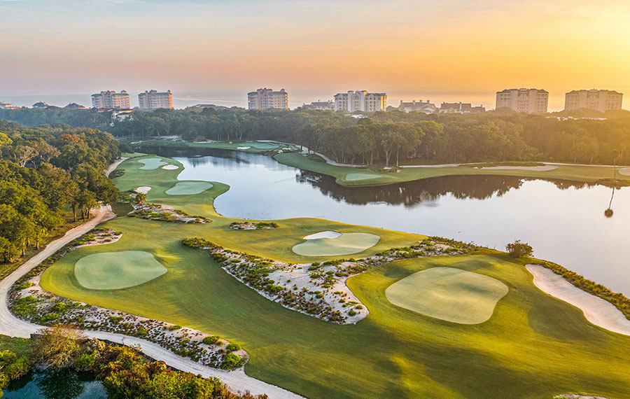 aerial view of golf course with beach hotel and sunrise sky at little sandy course omni amelia island resort