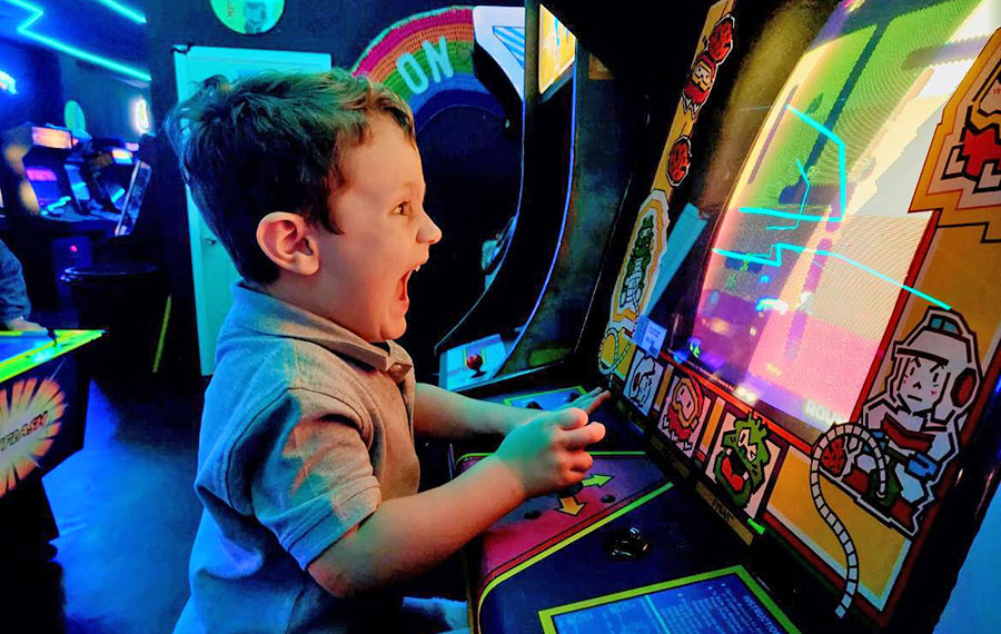 boy shouting while playing video game at the grid arcade pensacola