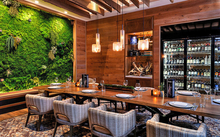 dining table with wooden wine cabinet and greenery at opal grand resort spa delray beach