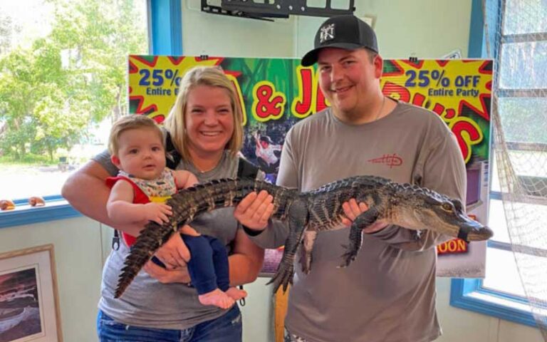 family of three holding gator indoor at tom jerrys airboat rides ocala orlando