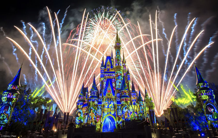 fireworks shooting up filling night sky over castle with projections of characters at happily ever after show magic kingdom disney world