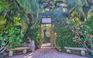 garden wall with iron gate and dense green foliage at cranes beach house boutique hotel luxury villas delray beach