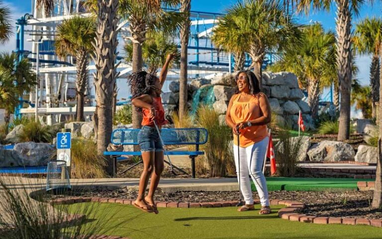 girl and mom playing mini golf at skywheel at pier park panama city beach