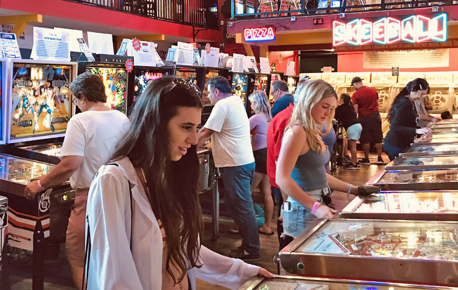 girls playing pinball machines with arcade background at silverball retro arcade delray beach