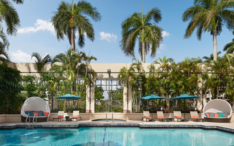 outdoor pool with cabanas and palms at boca raton marriott at boca center