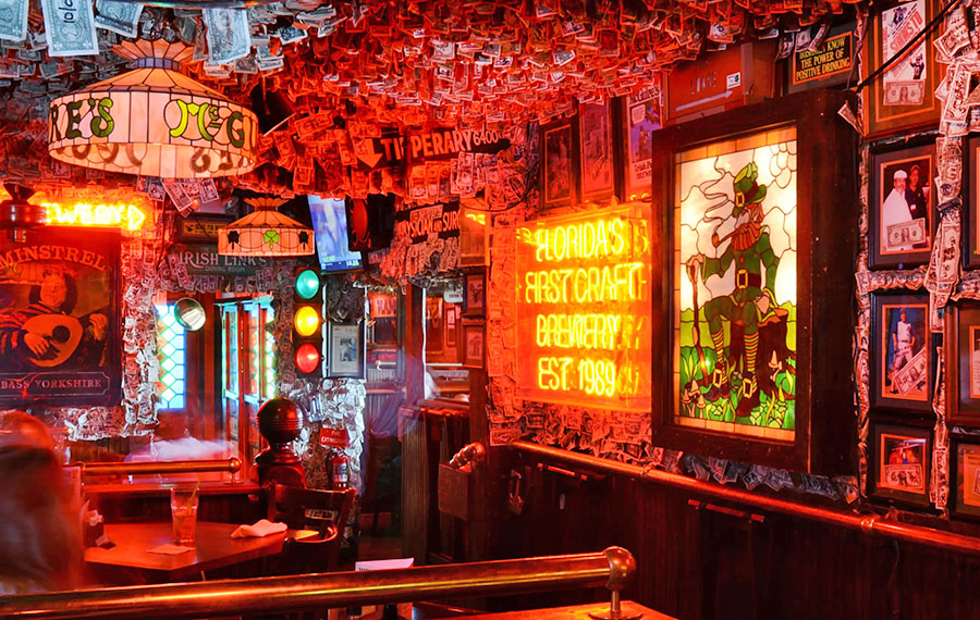 restaurant interior with red lighting irish decor and dollar bills carpeting ceiling at mcguires irish pub pensacola