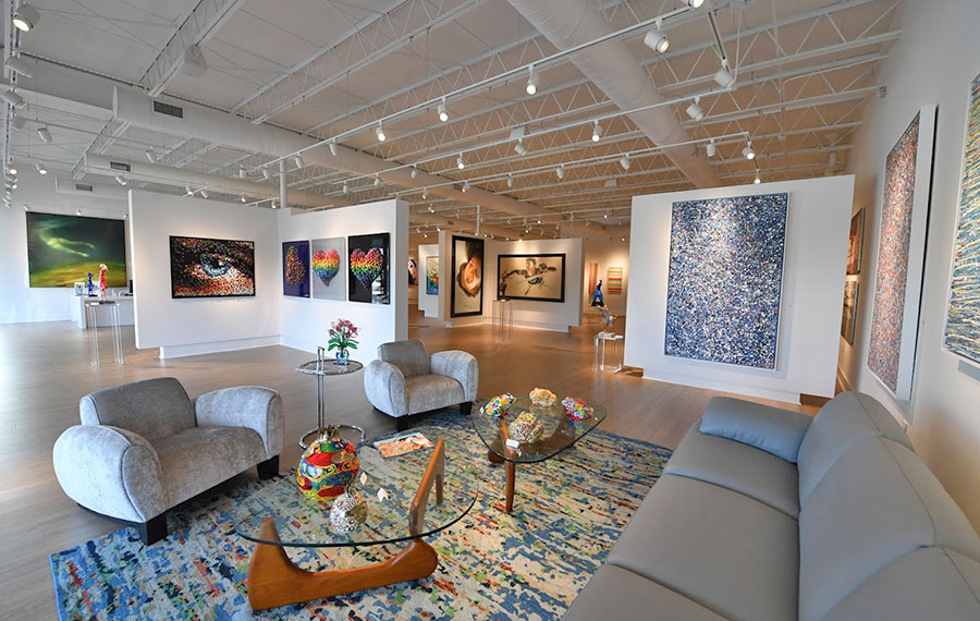 staged sales floor with art pieces and seating at blue gallery delray beach