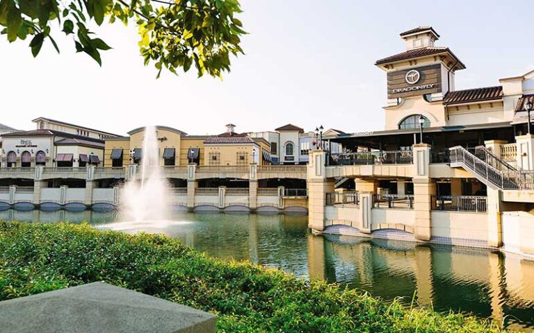 view across water with fountain and row of canalside shops at dellagio town center orlando