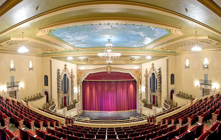 view from back row of theater seats and stage with red curtain at saenger theatre pensacola