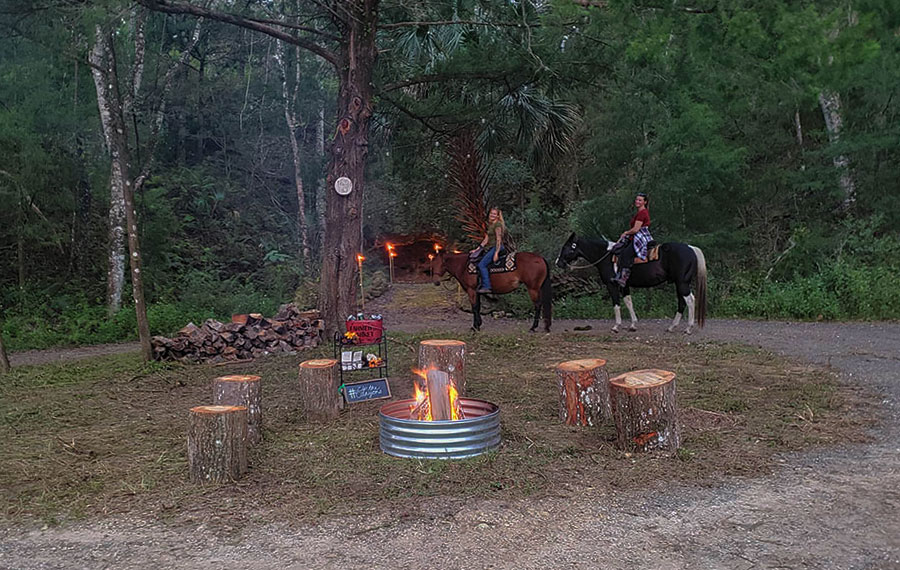 women on horses near trail with fire pit area at the canyons zip line and adventure park ocala