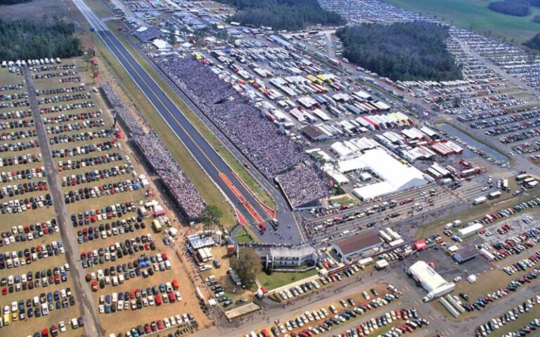 aerial view of drag race track with packed stands and parked cars at gainesville raceway