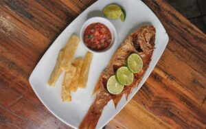 baked whole fish with sides on platter at tinker latin restaurant gainesville