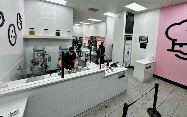 bakery interior with open kitchen employees prepping cookies at crumbl gainesville