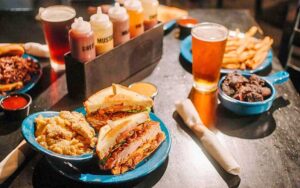 barbecue sandwiches and sauces on table at mojo hogtown bar b que gainesville