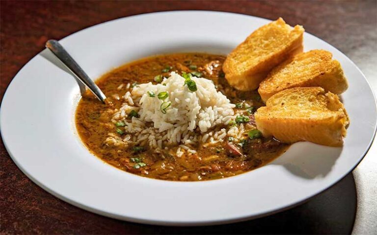 bowl of jambalaya with bread and spoon at dat cajun place cafe panama city beach