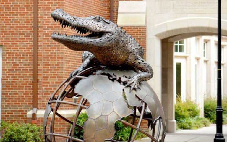 bronze sculpture of gator on globe in courtyard at university of florida gainesville