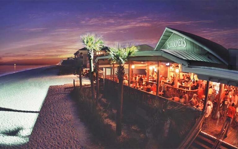 bustling dining area on beach at night at schooners panama city beach