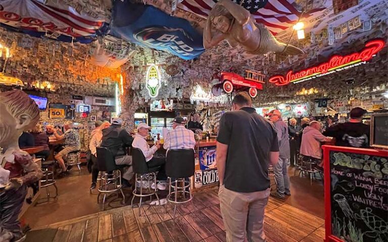 busy dining area with decor and dollars on ceiling at dustys oyster bar panama city beach