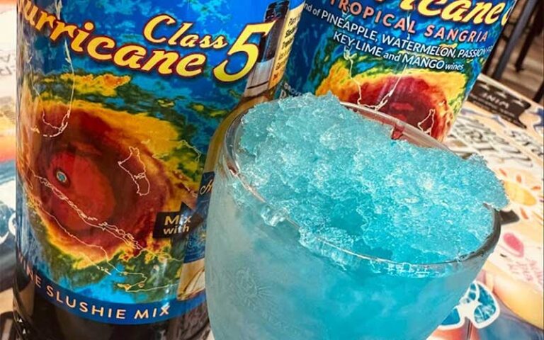 close up of blue slush drink with wine bottles behind at panama city beach winery