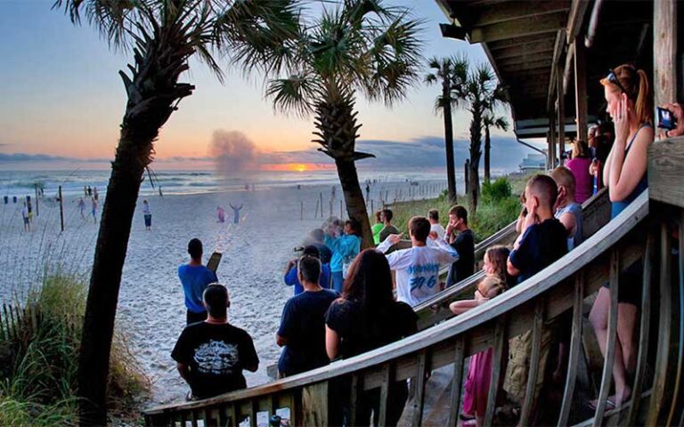 crowd watching sunset and cannon blast at schooners panama city beach