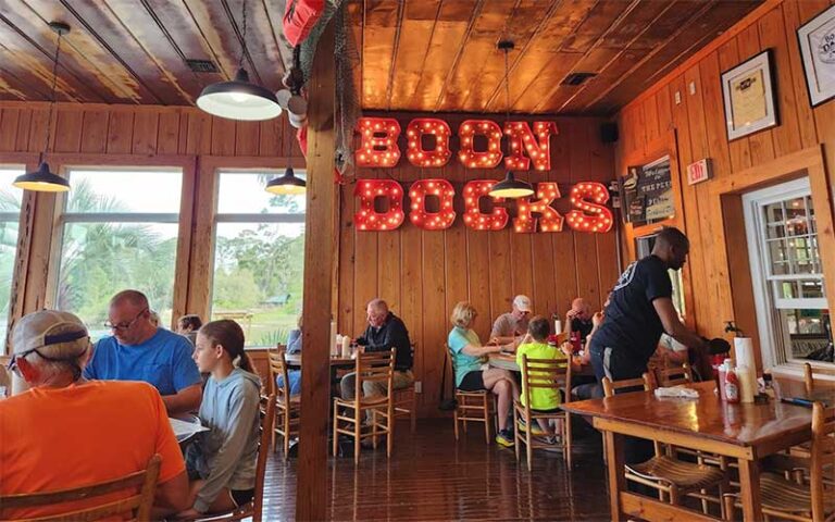 dining area interior with diners and sign at boon docks panama city beach