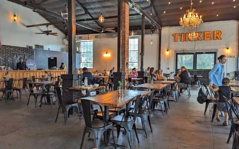 dining room interior with bar and sign at tinker latin restaurant gainesville