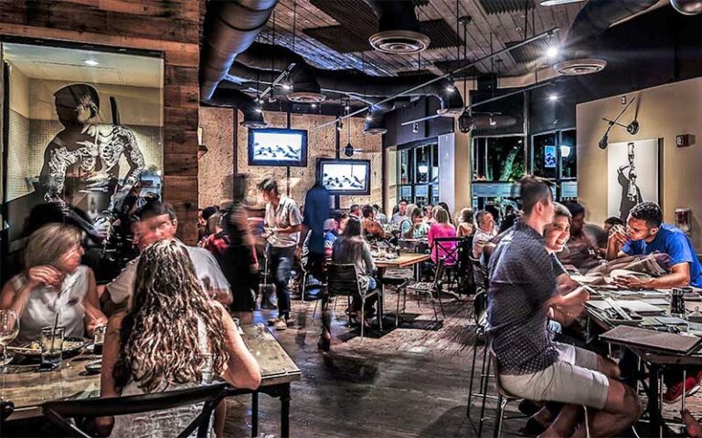 dining room with diners and servers at dragonfly sushi sake company gainesville