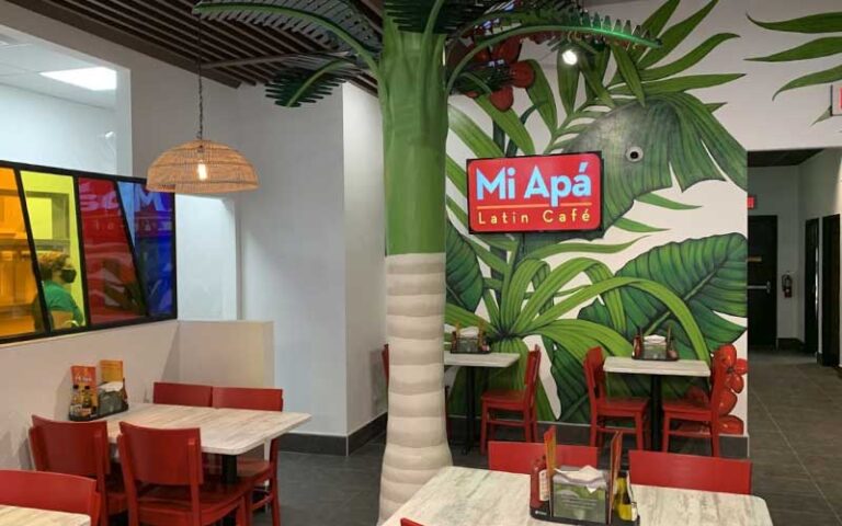 dining room with tropical theme and signs at mi apa latin cafe gainesville