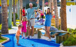 family cheer while toddler putts at coconut creek family fun park panama city beach