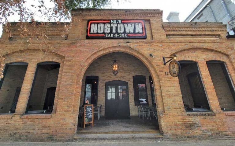 front exterior of brick restaurant with signs at mojo hogtown bar b que gainesville