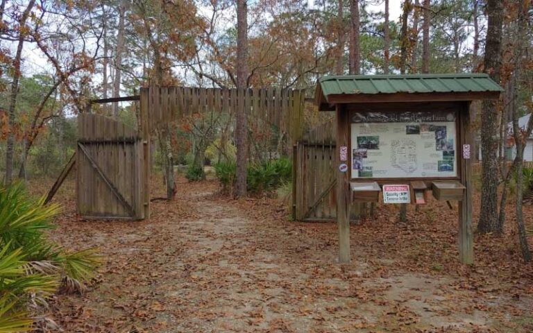 gated fence with park sign in woods at morningside nature center gainesville