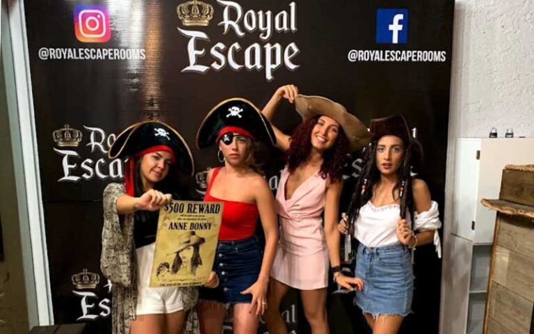 girls group posing with pirate props at royal escape games panama city beach