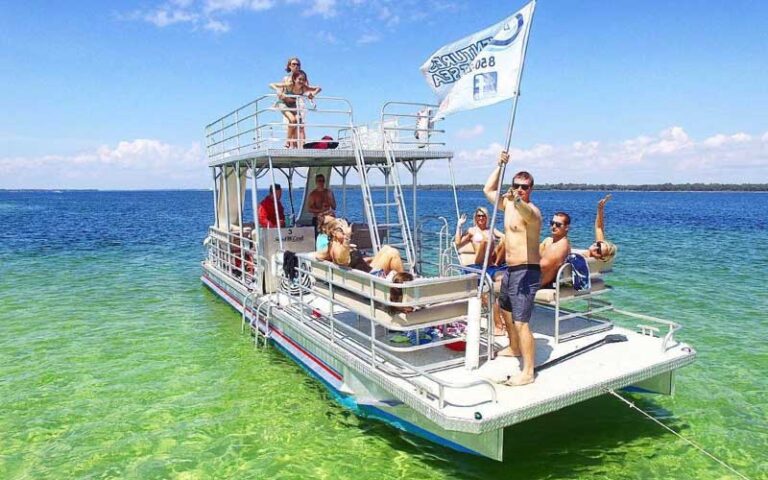 group having fun on pontoon rental over green blue water at adventures at sea panama city beach