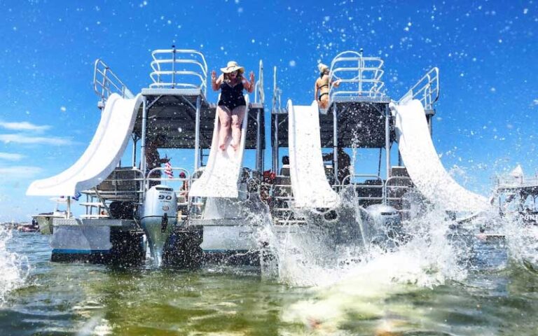 lady on slides on pontoon boat with splashing green water at adventures at sea panama city beach