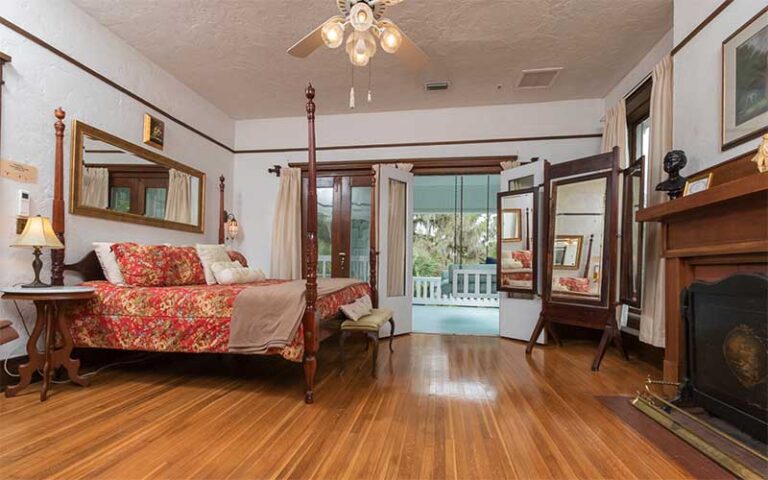 large bedroom with fireplace and balcony entrance at herlong mansion micanopy gainesville