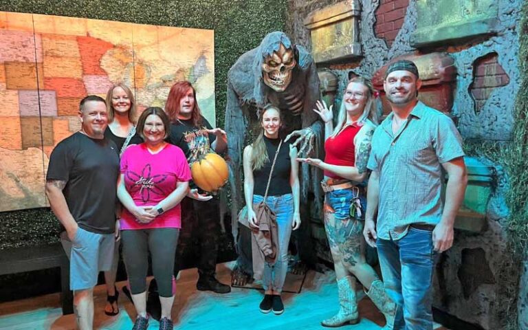 large group posing with grim reaper character at fear at the pier panama city beach