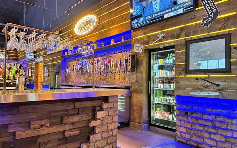 lighted rustic bar area with tvs and signs at fords garage gainesville